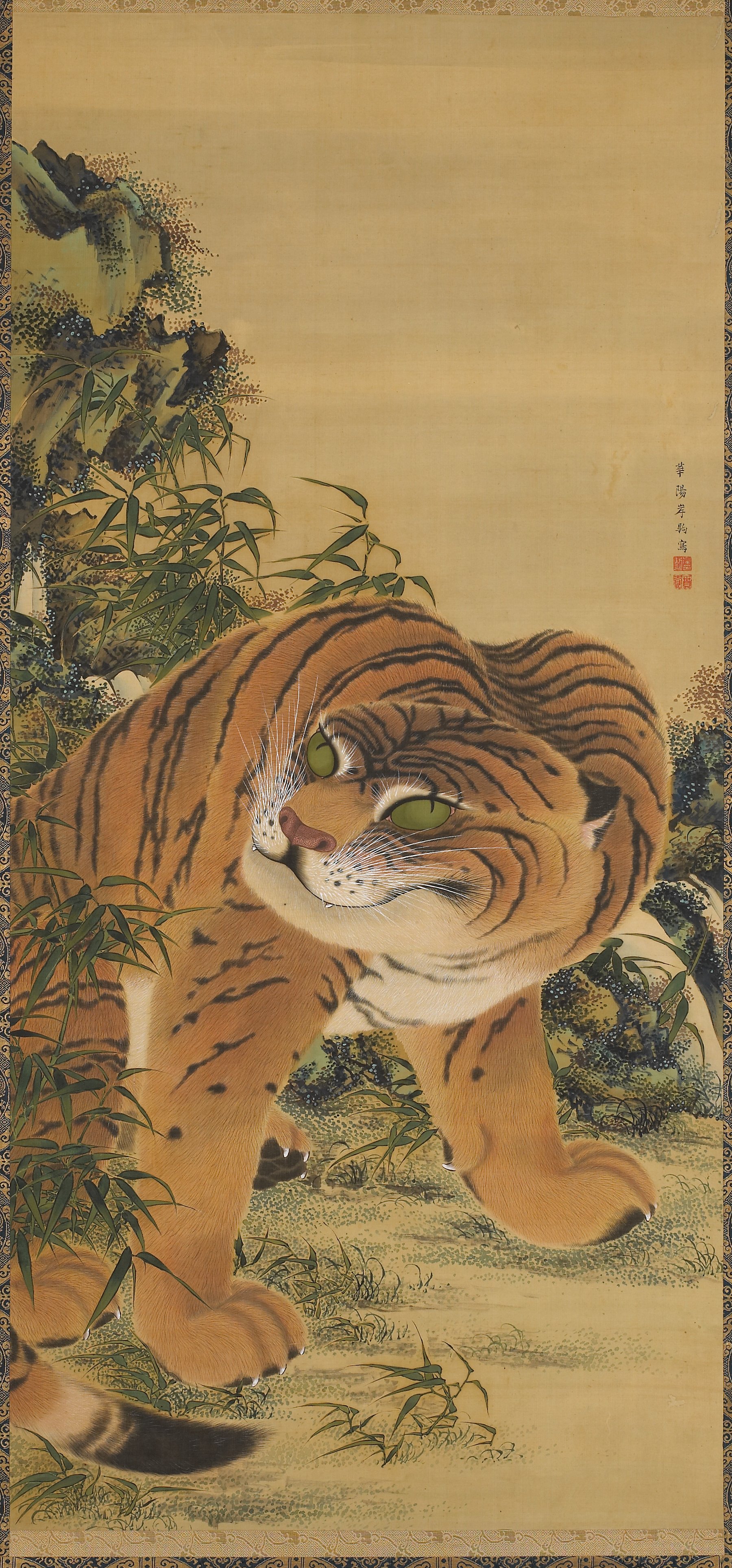 岩と竹の下に座る虎